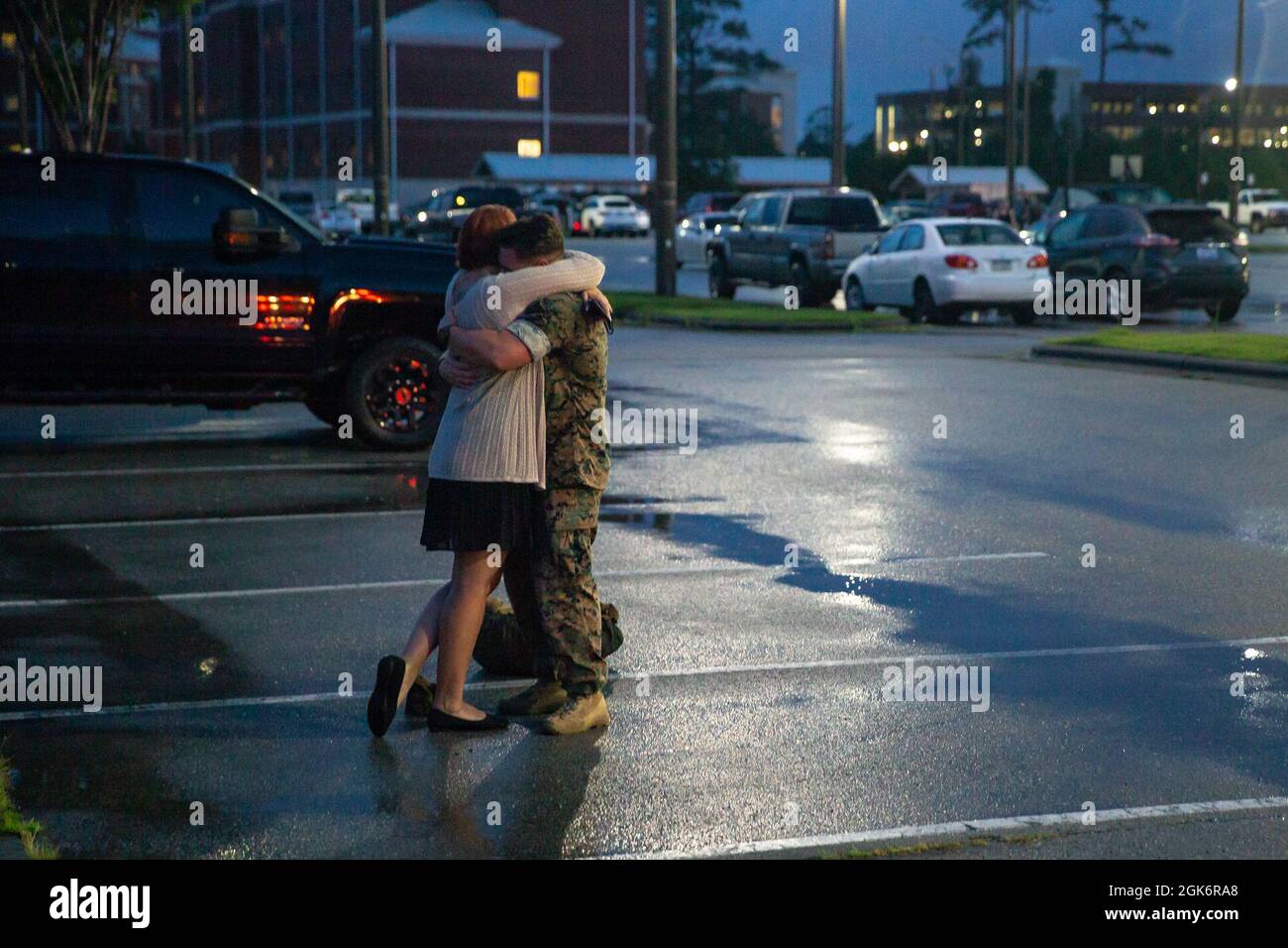 U.S. Marine Corps Chief Warrant Officer 2 Timothy Kalk, un Richland, Washington, nativo e un ufficiale di difesa chimica, biologica, radiologica e nucleare, con 2d Battaglione, 2d Marine Regiment (2/2), 2d Marine Division, abbraccia la sua famiglia durante un omonimo deploy a Camp Lejeune, N.C., 18 agosto 2021. Il 2/2 è tornato a Camp Lejeune dopo un programma di distribuzione di unità di sei mesi a Okinawa, Giappone. Foto Stock