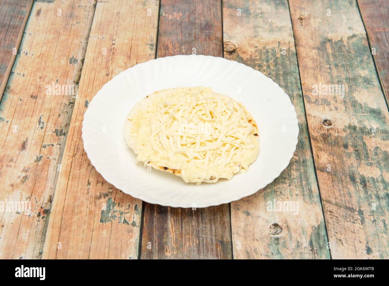 arepa semplice con formaggio sopra su piatto bianco Foto Stock