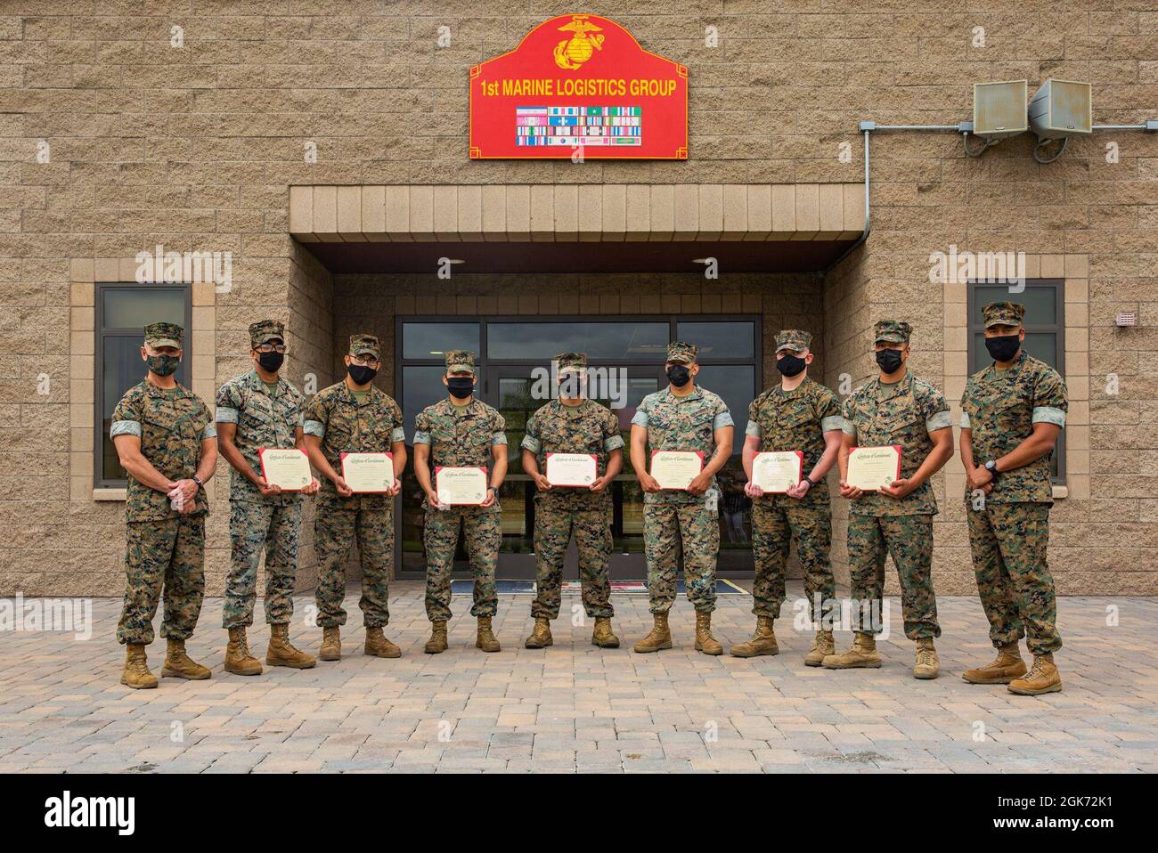 I Marines USA con il 1° Marine Logistics Group, i Marine Expeditionary Force, che recentemente ha riarruolato, posano per una foto di gruppo presso il 1° MLG Headquarters Building a Camp Pendleton, California, 20 agosto 2021. I migliori e più qualificati Marines dell'anno fiscale 2022 possono riarruolarsi come parte della missione di mantenimento del comando dell'anno fiscale 22. La missione è una campagna in corso per mantenere i Marines migliori e più qualificati al fine di sostenere il nostro corpo Marino. Foto Stock