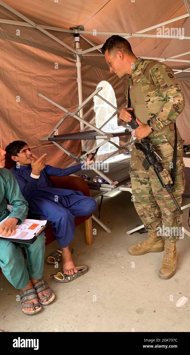 Lo Specialista Liam Dixon con la XVIII divisione Airborne Corps' 82nd Airborne sta lavorando per sostenere il Dipartimento di Stato con l'evacuazione sicura dei visti speciali immigrati afghani all'Aeroporto Internazionale Hamid Karzai, agosto 20. Foto Stock