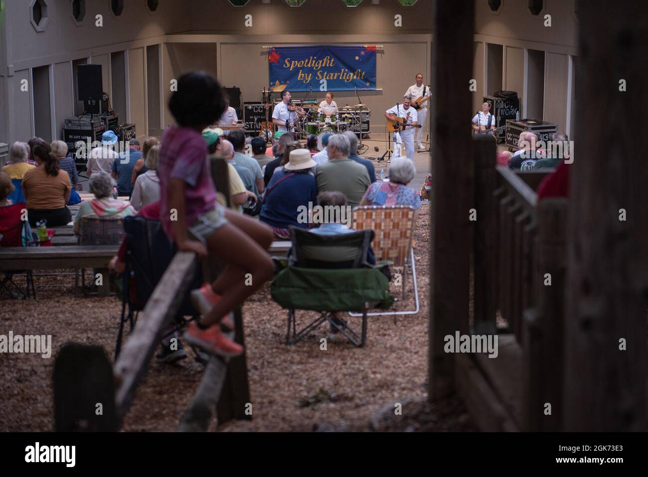 Un giovane membro del pubblico ascolta la US Navy Band Country Current esibirsi al Mason District Park di Annadale, Virginia, come parte della missione di outREACH della serie di concerti estivi della band. Foto Stock