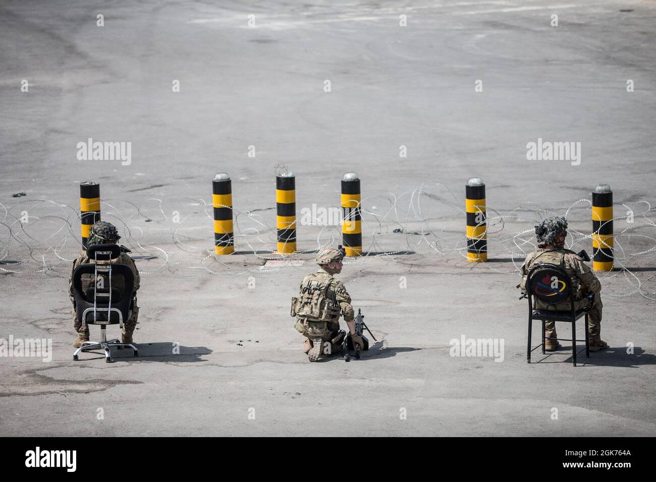 I soldati con la 82° Divisione Airborne, forniscono assistenza durante un'evacuazione all'Aeroporto Internazionale Hamid Karzai, Kabul, Afghanistan, 22 agosto. I membri del servizio degli Stati Uniti stanno assistendo il Dipartimento di Stato con un prelievo ordinato di personale designato in Afghanistan. Foto Stock