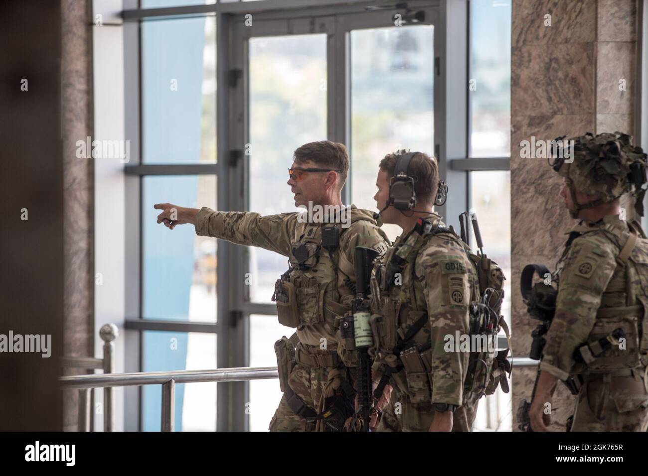 I soldati con la 82° Divisione Airborne discutono il piano di manovra durante un'evacuazione all'Aeroporto Internazionale Hamid Karzai, Kabul, Afghanistan, 22 agosto. I membri del servizio degli Stati Uniti stanno assistendo il Dipartimento di Stato con un prelievo ordinato di personale designato in Afghanistan. Foto Stock
