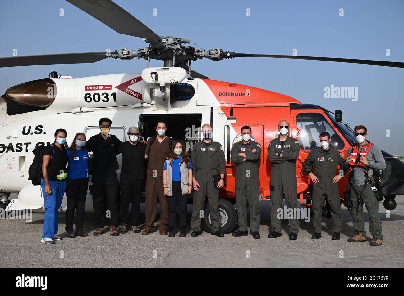 I membri dell'equipaggio di un MH-60 Jayhawk Helicopter trasportano personale medico di assistenza Acadena da Port-au-Prince, Haiti a Les Cayes, Haiti 22 agosto 2021. La Guardia Costiera ha impegnato numerose attività aeree e di superficie per il trasporto di operatori medici e forniture. Foto Stock