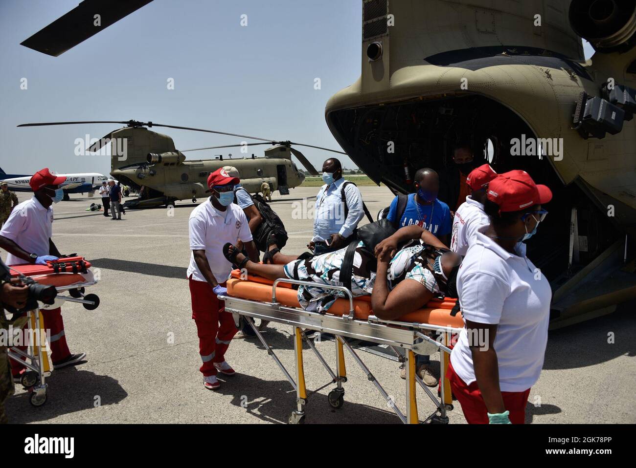 Un esercito degli Stati Uniti CH-47 Chinook Helicopter equipaggio e partner agenzie di salvataggio trasferire un paziente a seguito di una evacuazione medica a Port-au-Prince, Haiti, 23 agosto 2021. La Guardia Costiera ha condotto sforzi umanitari in aree colpite di Haiti a seguito di un terremoto di magnitudo 7.2, 14 agosto 2021. (. Foto Stock