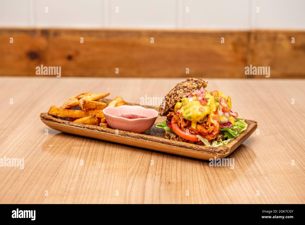 hamburger di costolette con pomodoro, lattuga iceberg, spicchi di patate, formaggio cheddar fuso e cipolla sminuzzata cruda Foto Stock