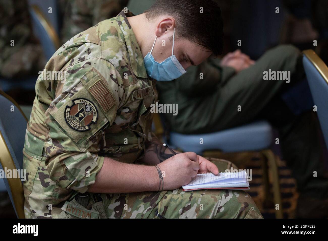 Airman 1st Class Kyler Williams, 36th Airlift Squadron C-130J Super Hercules loadmaster, prende una nota durante il Master Sergente capo dell'Air Force Joanne Bass ha arruolato tutte le chiamate alla Yokota Air base, Giappone, 25 agosto 2021. Durante la chiamata all-in-listed, Bass ha parlato delle sue aree di interesse, tra cui le persone, la disponibilità e la cultura. Foto Stock