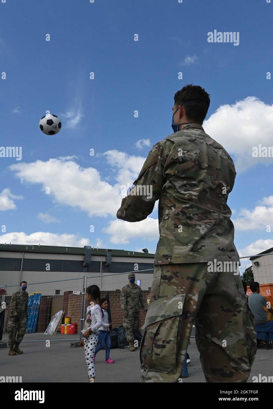 Airman 1st Class Liam Marshman, 4th Space Operations Squadron Military satellite Communications maintainer, gioca con gli evacuati durante l'operazione Allees Refuge alla base aerea di Ramstein, Germania, 25 agosto 2021. Soldati, Airmen e marinai contribuiscono tutti a modo loro a migliorare la qualità della vita e il morale di tutti gli sfollati della RAB. Foto Stock