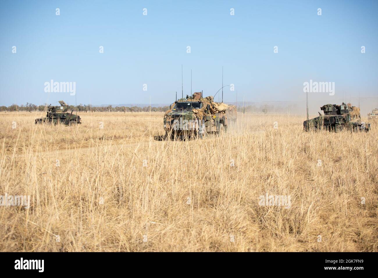 I Marines degli Stati Uniti con il plotone rosso combinato della squadra anti-armor con la forza rotazionale Marina - Darwin, mantengono un punto in avanti mentre i soldati dell'esercito australiano con il 1° reggimento armorato passano attraverso con i veicoli di mobilità protetta di Bushmaster durante l'esercitazione Koolendong, Bradshaw Field Training Area, NT, Australia, 25 agosto 2021. La missione del plotone rosso CAAT durante le prove era quella di fornire supporto al fuoco in collaborazione con 1 ARMD Regt. Exercise Koolendong convalida la MRF-D e la capacità della forza di difesa australiana di condurre operazioni di comando e controllo di spedizione, dimostrando l’impegno condiviso Foto Stock