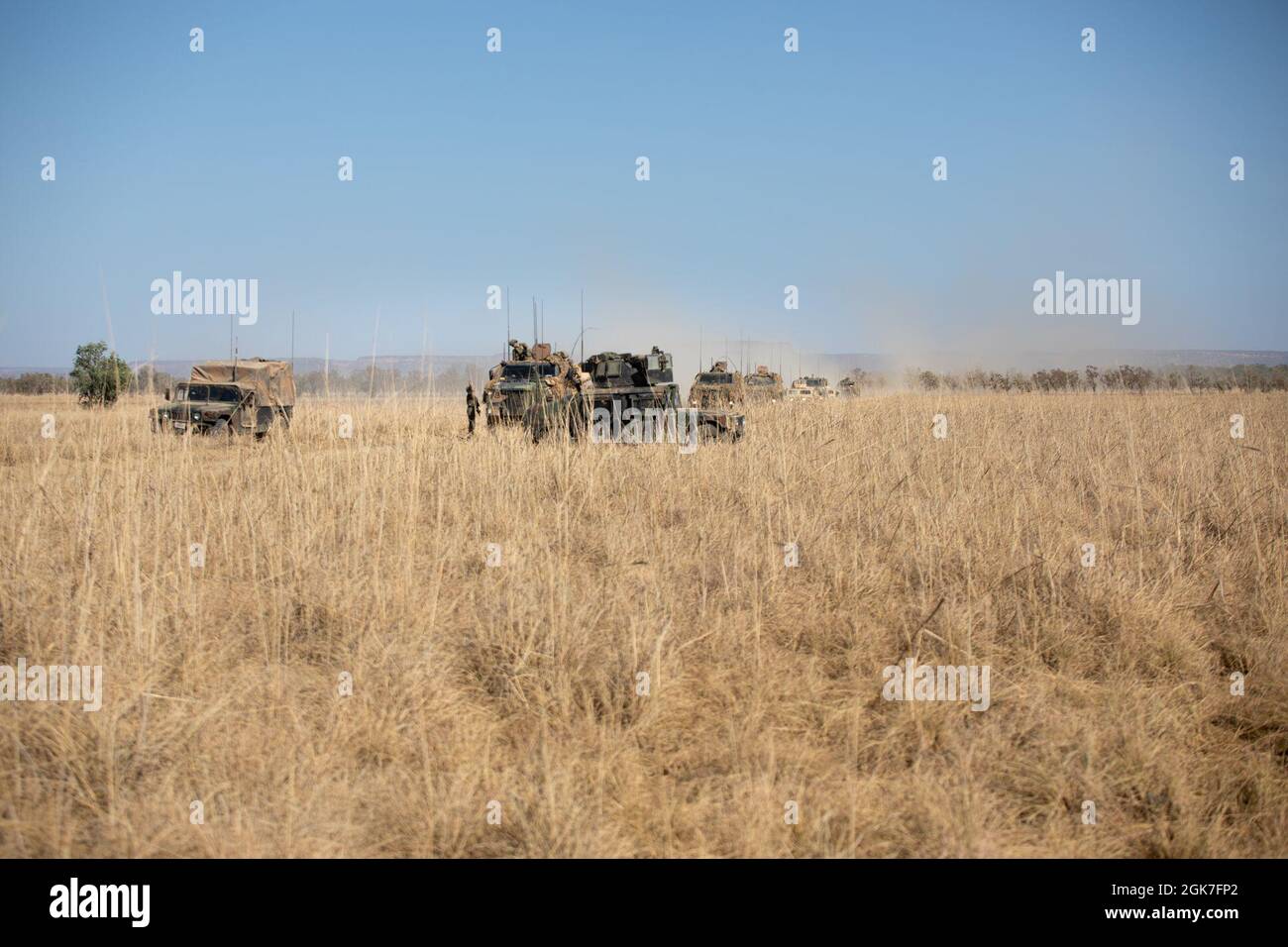 I Marines degli Stati Uniti con il plotone rosso combinato della squadra anti-armor con la forza rotazionale Marina - Darwin, mantengono un punto in avanti mentre i soldati dell'esercito australiano con il 1° reggimento armorato passano attraverso con i veicoli di mobilità protetta di Bushmaster durante l'esercitazione Koolendong, Bradshaw Field Training Area, NT, Australia, 25 agosto 2021. La missione del plotone rosso CAAT durante le prove era quella di fornire supporto al fuoco in collaborazione con 1 ARMD Regt. Exercise Koolendong convalida la MRF-D e la capacità della forza di difesa australiana di condurre operazioni di comando e controllo di spedizione, dimostrando l’impegno condiviso Foto Stock