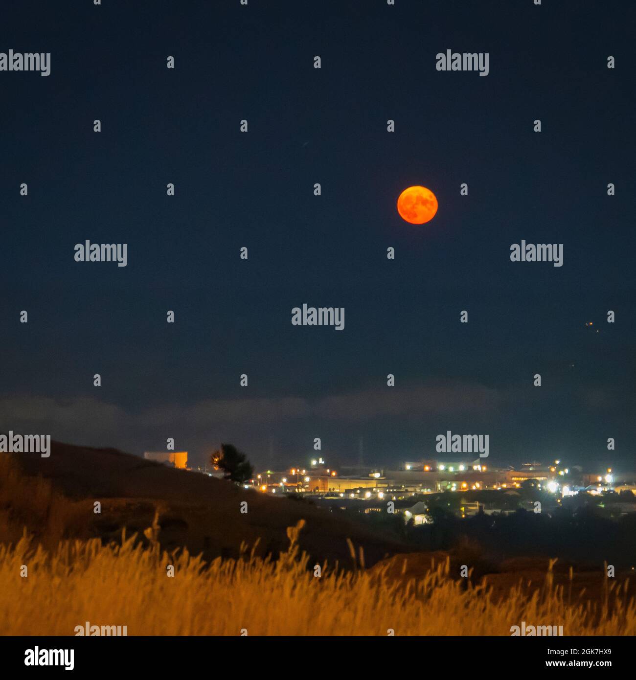 Luna piena super che si alza sopra le luci di Billings , Montana Foto Stock