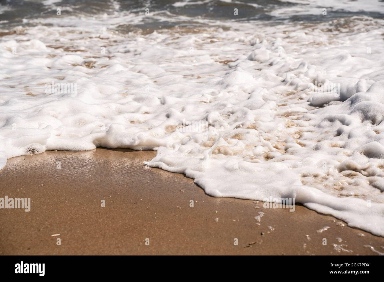 Ocean Nature immagine di dettagli ravvicinati come acqua schiumosa come le onde si lavano sulla riva alla spiaggia Foto Stock