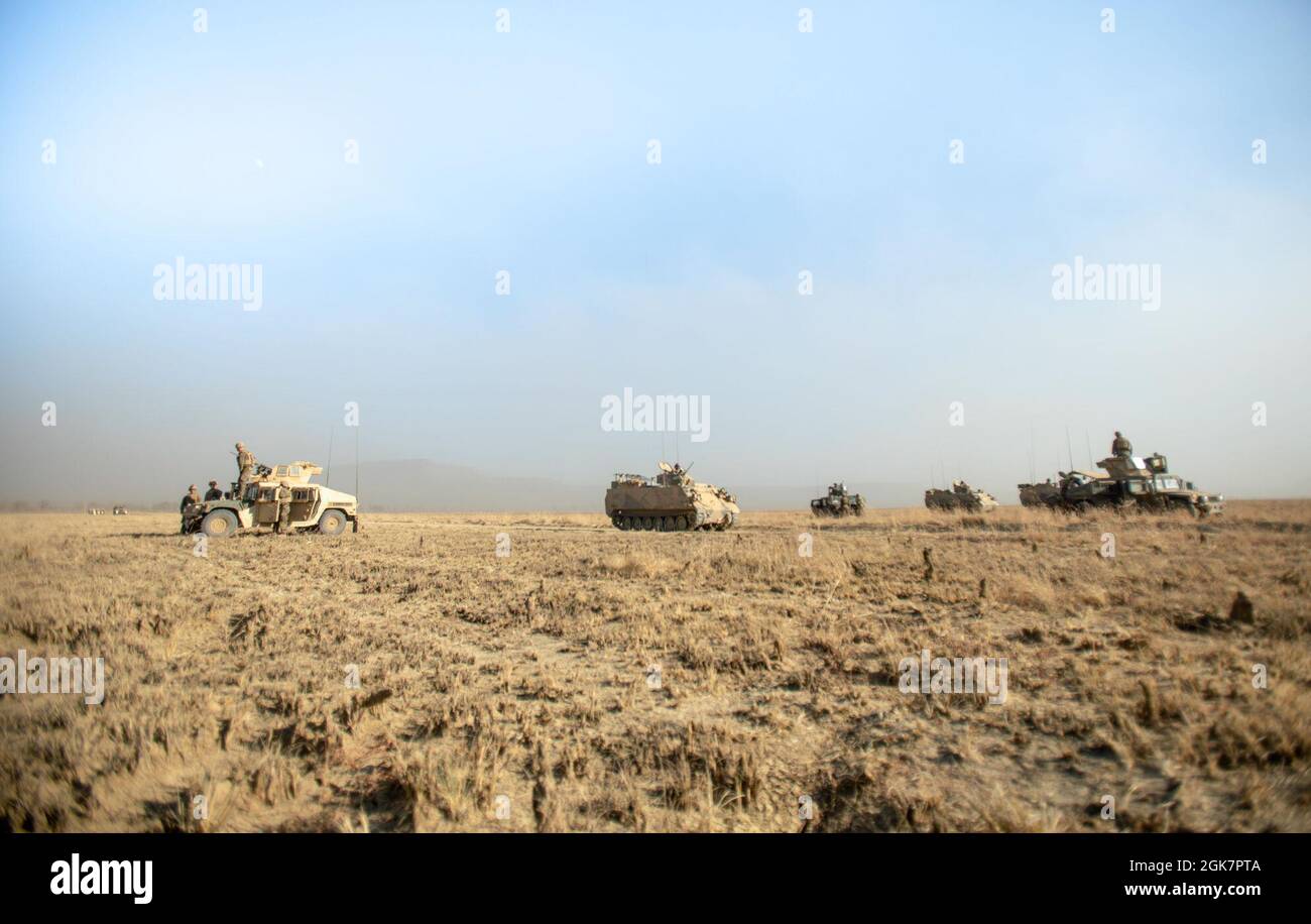 Un vettore Armored del personale dell'esercito australiano M113AS4 passa dai marines degli Stati Uniti con il plotone rosso combinato del team di Anti-Armor, forza rotazionale marina - Darwin, tenendo una linea di fase per lo scenario di fuoco vivo durante l'esercitazione Koolendong, Bradshaw Field Training Area, NT, Australia, 28 agosto 2021. Il plotone CAAT Red era delimitato in un campo con varie armi per cogliere una linea di fase chiave che consentiva ad altri veicoli tattici di passare attraverso e procedere con l'esercizio. Esercizi come Koolendong convalidano la capacità della MRF-D e della forza di difesa australiana di condurre un comando e un controllo rapido Foto Stock