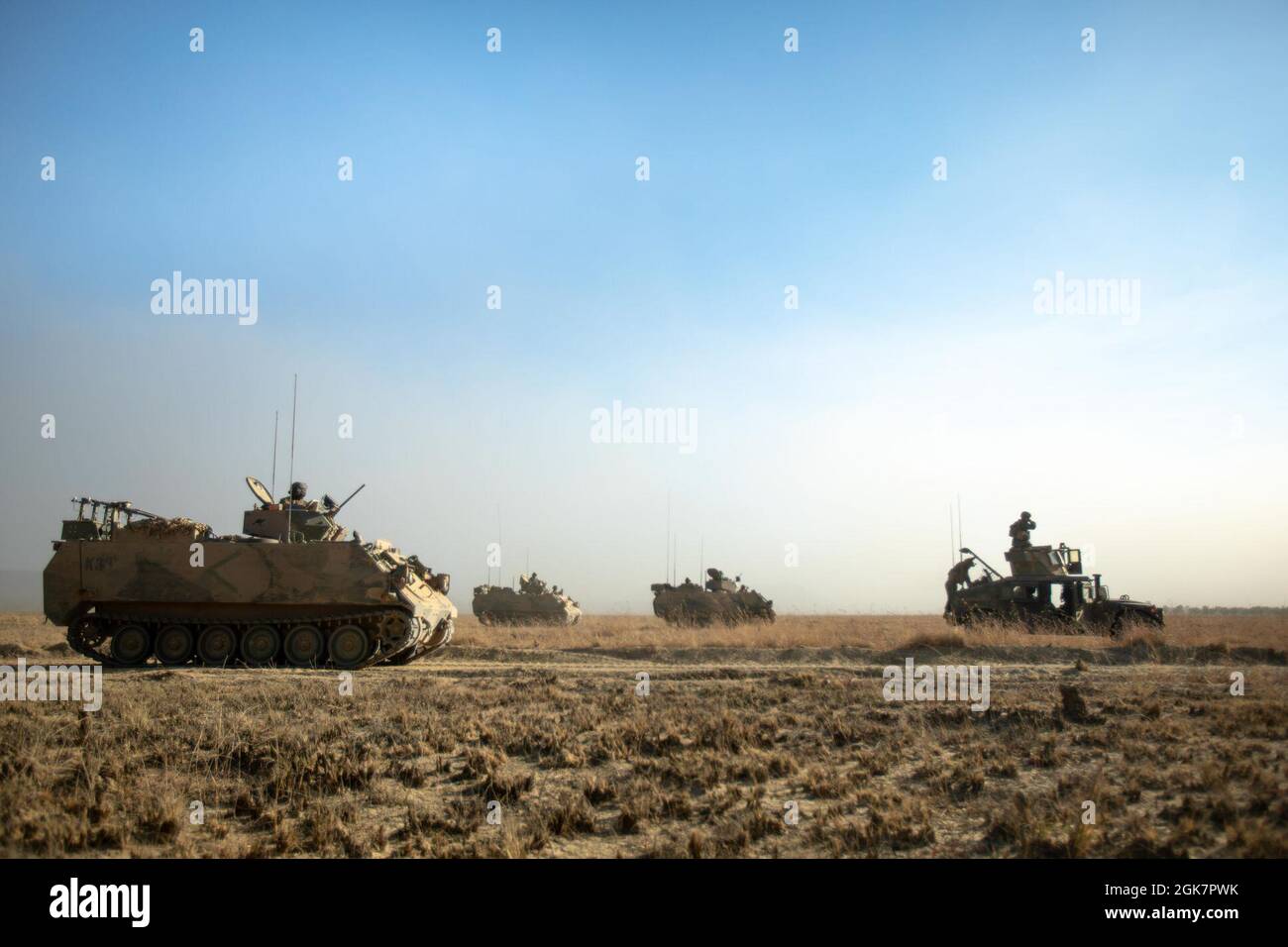 L'esercito australiano M113AS4 le carrier Armored del personale passano dai marines degli Stati Uniti con il plotone rosso del team di Anti-Armor combinato, forza rotazionale marina - Darwin, tenendo una linea di fase per lo scenario di fuoco vivo durante l'esercitazione Koolendong, Bradshaw Field Training Area, NT, Australia, 28 agosto 2021. Il plotone CAAT Red era delimitato in un campo con varie armi per cogliere una linea di fase chiave che consentiva ad altri veicoli tattici di passare attraverso e procedere con l'esercizio. Esercizi come Koolendong convalidano la capacità della MRF-D e della forza di difesa australiana di condurre operazioni di comando e controllo rapide Foto Stock