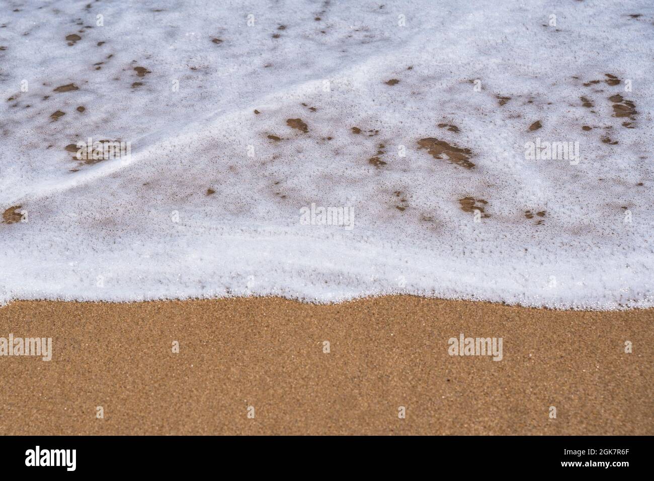 Ocean Nature immagine di dettagli ravvicinati come acqua schiumosa come le onde si lavano sulla riva alla spiaggia Foto Stock
