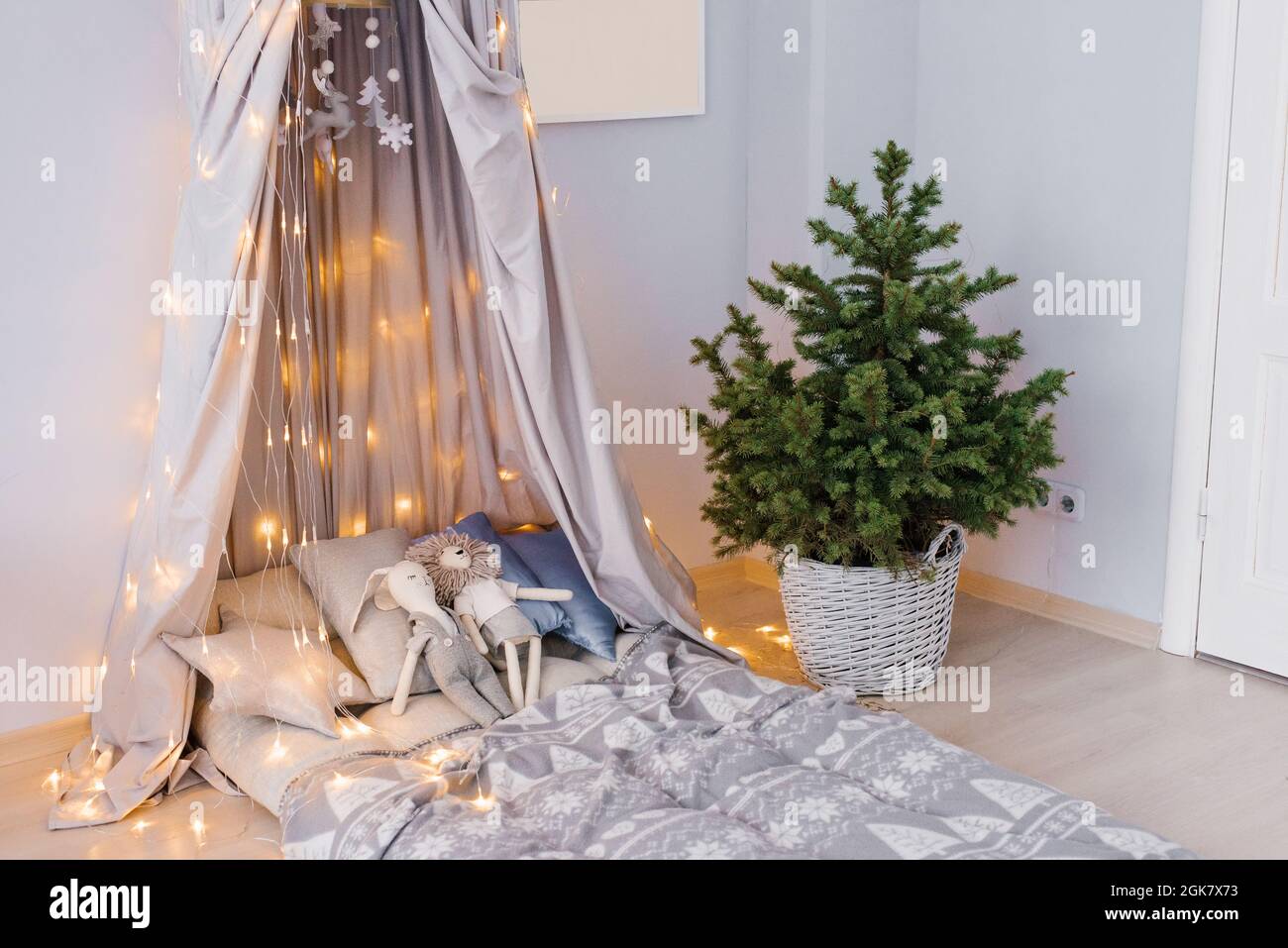 Camera per bambini elegante e moderna. Letto per bambini con tenda. Albero  di Natale in un cestino di vimini. Interni in stile scandinavo Foto stock -  Alamy