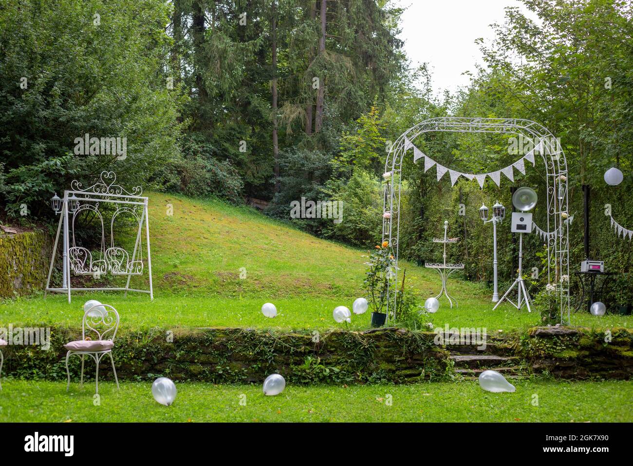 Altare di nozze all'aperto nel cortile posteriore con un cuore decorativo a forma di swing e palloncini Foto Stock