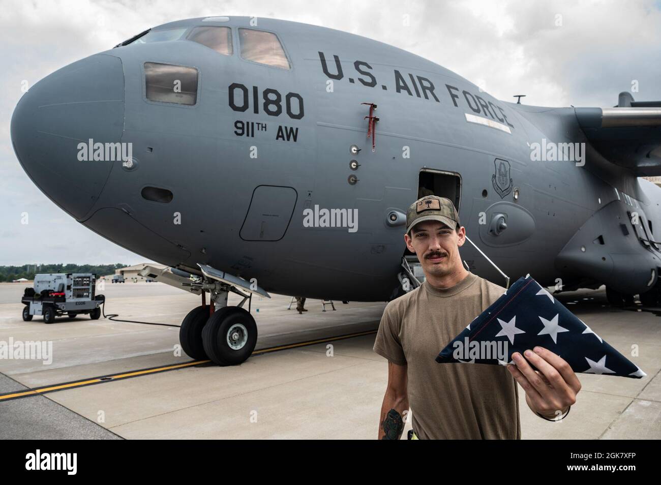 Tecnologia. SGT. Nick Boswell, 911th Aircraft Maintenance Squadron Crew Chief, detiene una bandiera americana ripiegata di fronte a un C-17 Globemaster III presso la stazione di riserva aerea dell'aeroporto internazionale di Pittsburgh, Pennsylvania, 31 agosto 2021. La bandiera è stata appesa nel vano di carico e fluì nell'aeromobile durante le missioni di evacuazione in e fuori dall'Afghanistan. Foto Stock