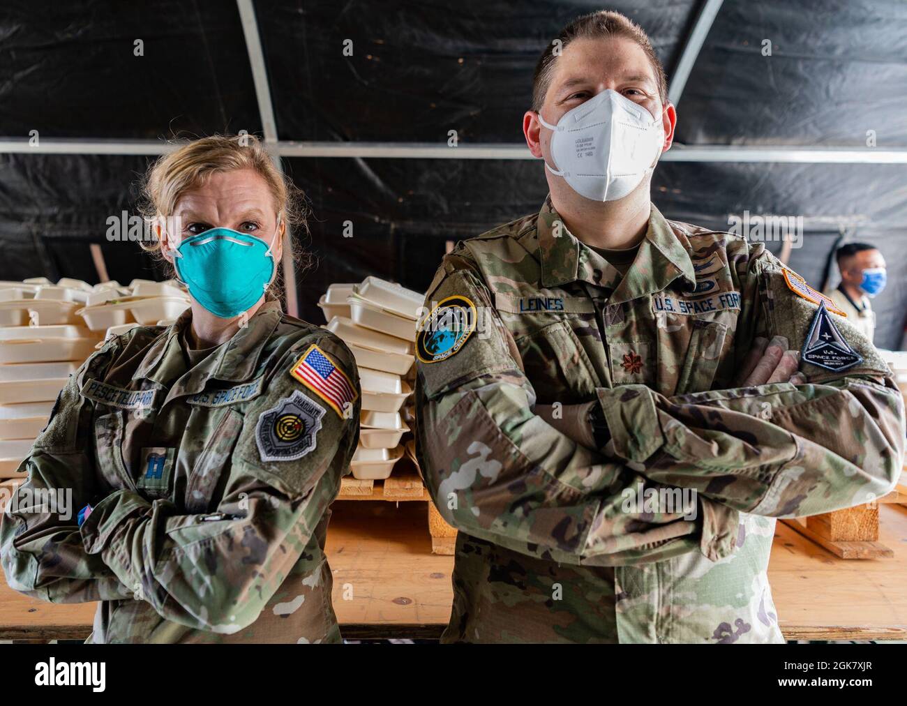 Justine Pescetello-Parr, sinistra, 603rd Air Operations Center, operatore di armi spaziali, e il Major Matthew Leines, 603rd AOC vice direttore del centro spaziale North Atlantic Treaty Organization, si trova di fronte a un centro di distribuzione di cibo presso la Ramstein Air base, Germania, 31 agosto 2021. I volontari lavorano 24 ore su 24 per sostenere gli evacuati durante il loro tempo a Ramstein mentre attendono il trasporto negli Stati Uniti e in altri luoghi sicuri. Foto Stock