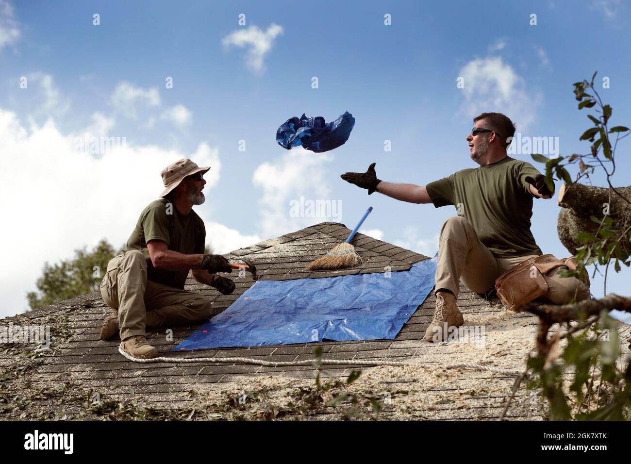 Gli agenti della pattuglia di confine degli Stati Uniti riparano temporaneamente un tetto residenziale perforato con un tarp dopo l'uragano Ida vicino a Baton Rouge, la., 31 agosto 2021. Foto Stock