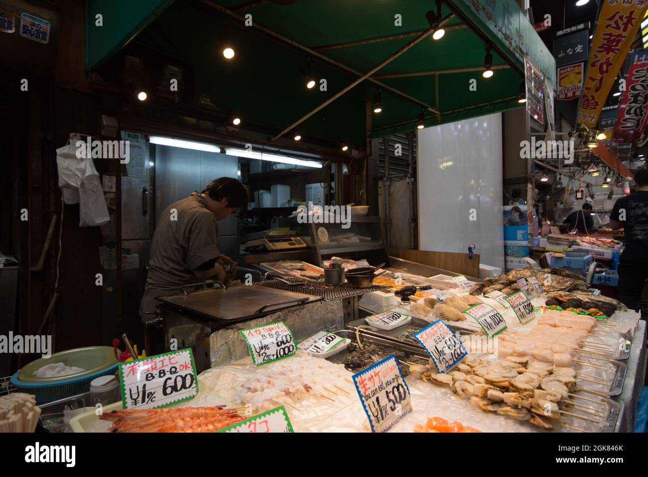 Bancarelle di pesce con prodotti appena pescati al mercato Kuromon Ichiba, Osaka, Giappone Foto Stock