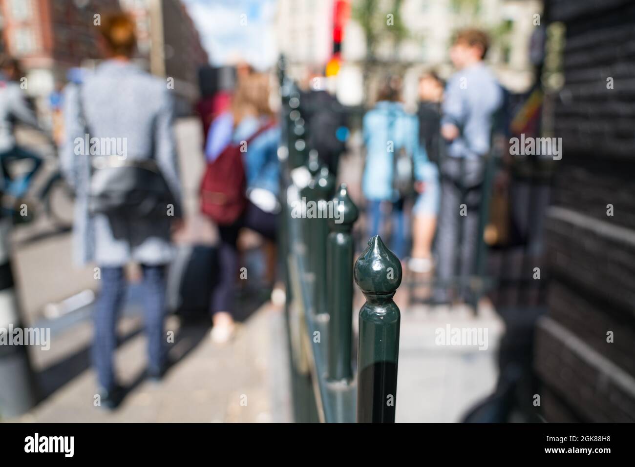 Immagine di sfondo sfocata e sfocata con balaustra in ferro battuto nella città di Amsterdam Paesi Bassi e pedoni che passano. Foto Stock
