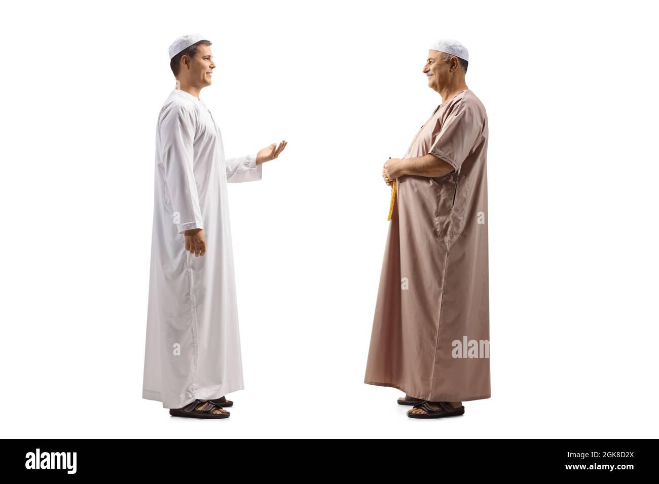 Scatto a tutto profilo di due uomini in abiti etnici che hanno una conversazione isolato su sfondo bianco Foto Stock