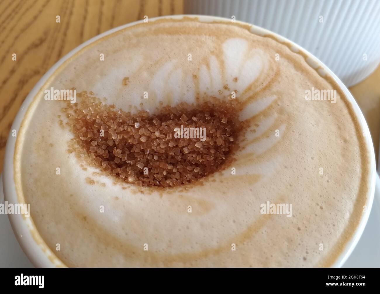 Cappuccino in una tazza con zucchero di canna, macro Foto Stock