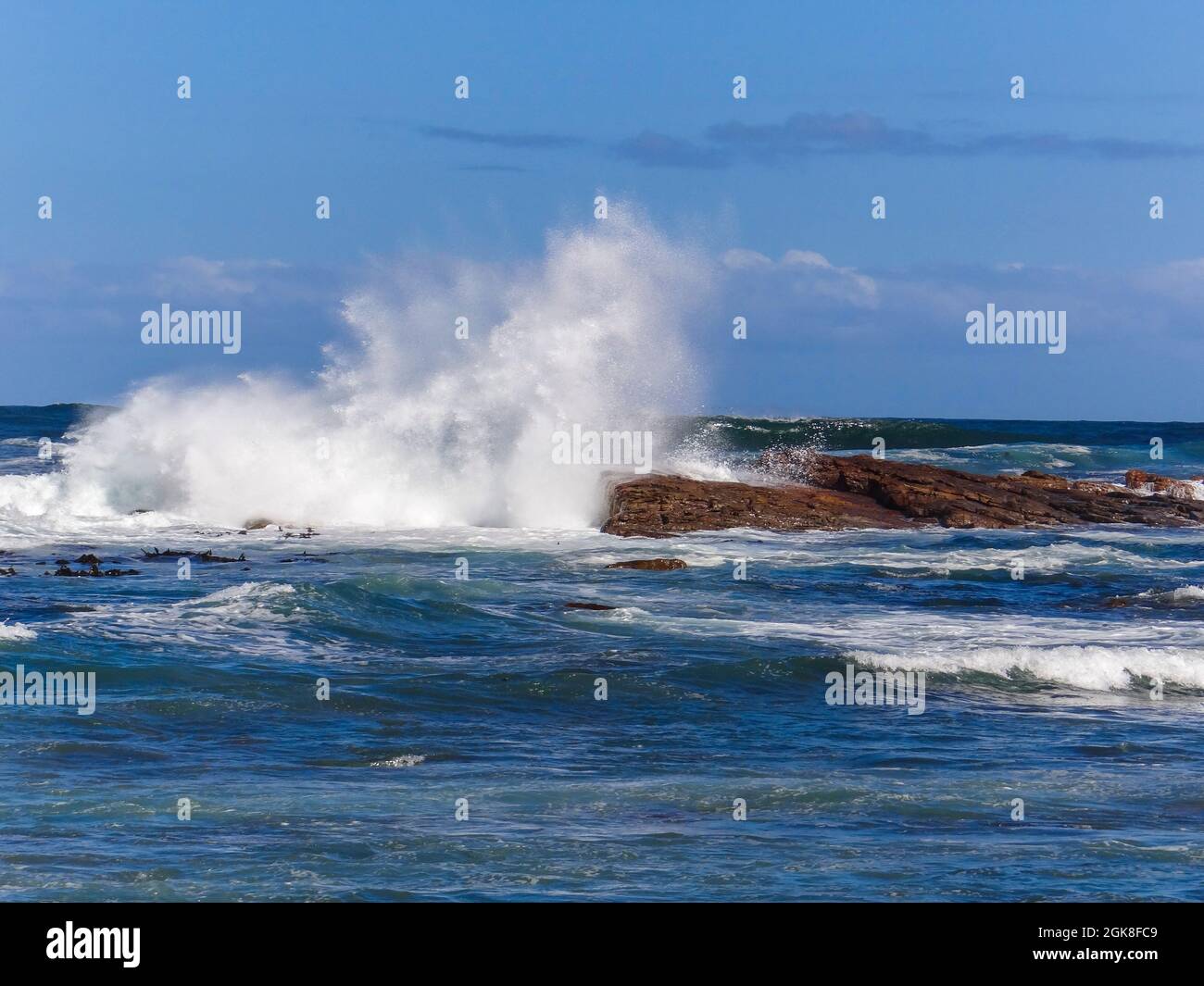 Onde che si infrangono sulle rocce al largo della costa africana Foto Stock