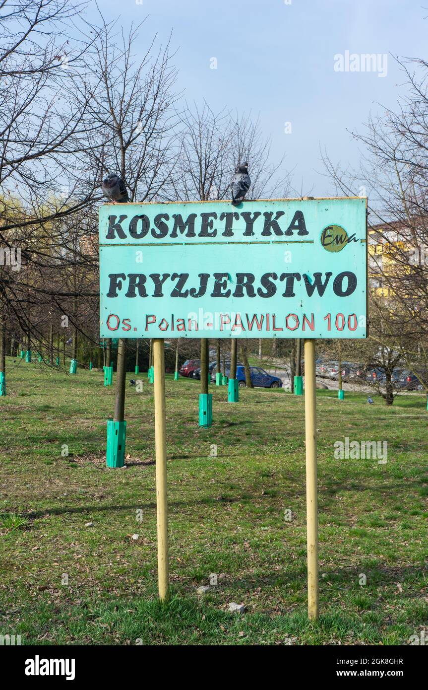 POZNAN, POLONIA - Apr 04, 2016: Un vecchio bordo di pubblicità verde con 'cosmetology and hairdressing' scritto su di esso in un parco Foto Stock