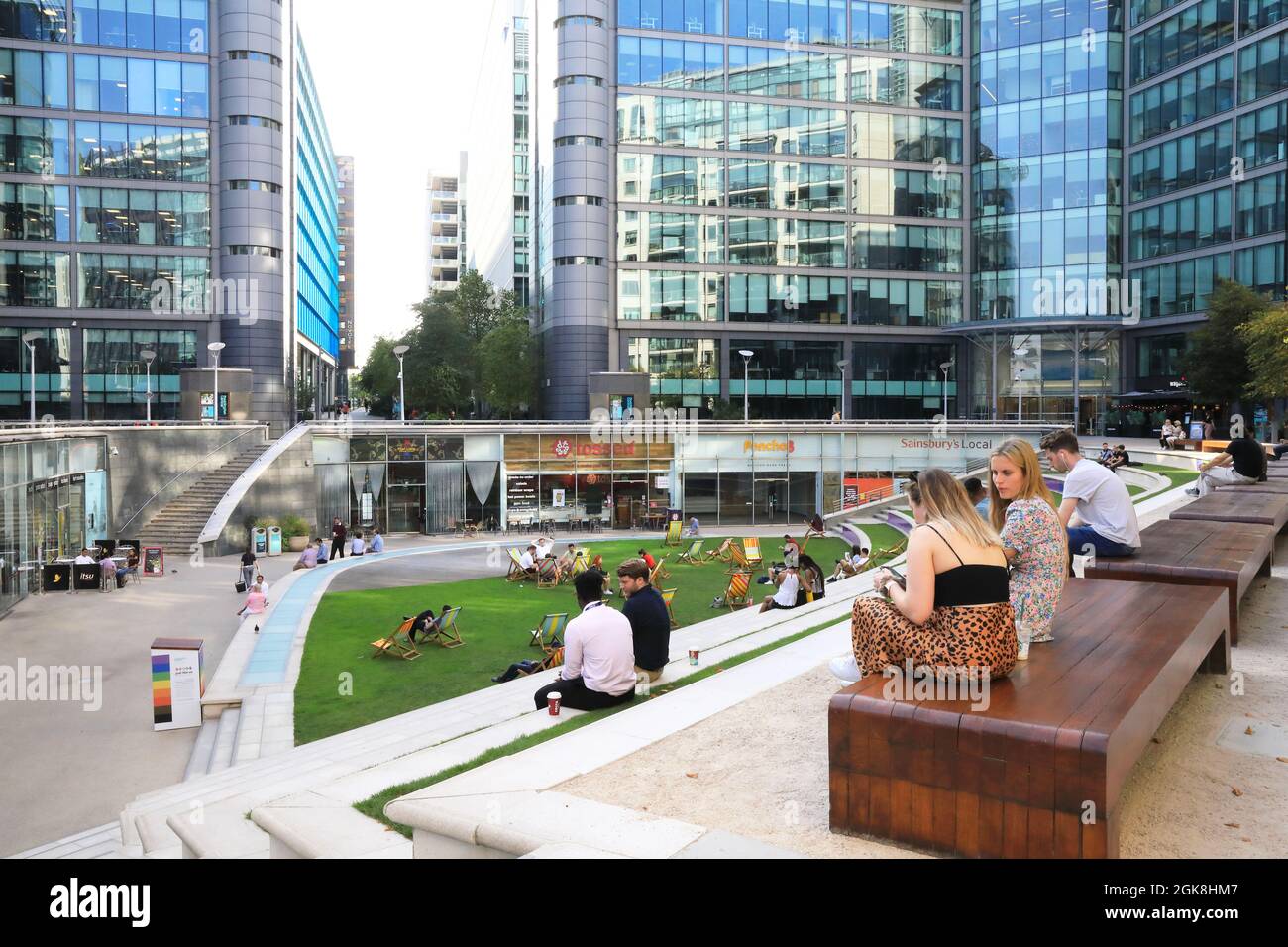 Lavoratori che siedono tra gli uffici aziendali di Sheldon Square, in un pomeriggio caldo e soleggiato, a Paddington Central, Londra occidentale, REGNO UNITO Foto Stock