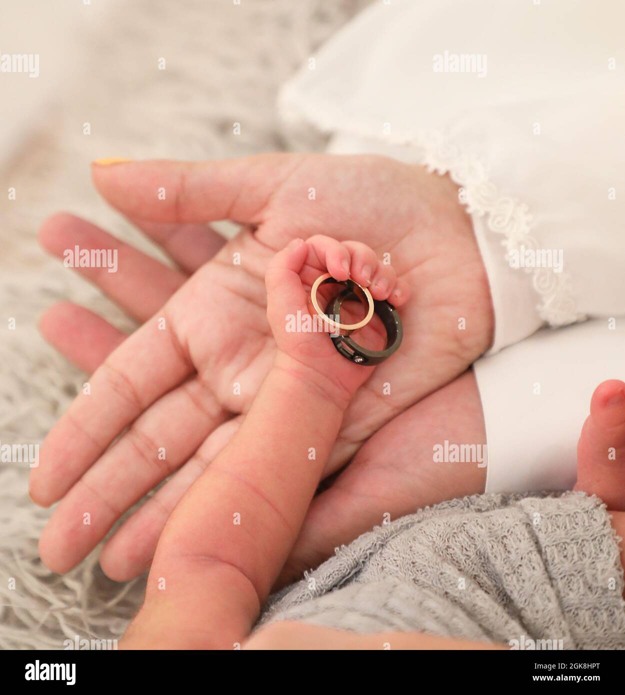 primo piano degli anelli di tenuta della mano del bambino cute del neonato,  palma di cura della madre, concetto pacifico di salute Foto stock - Alamy