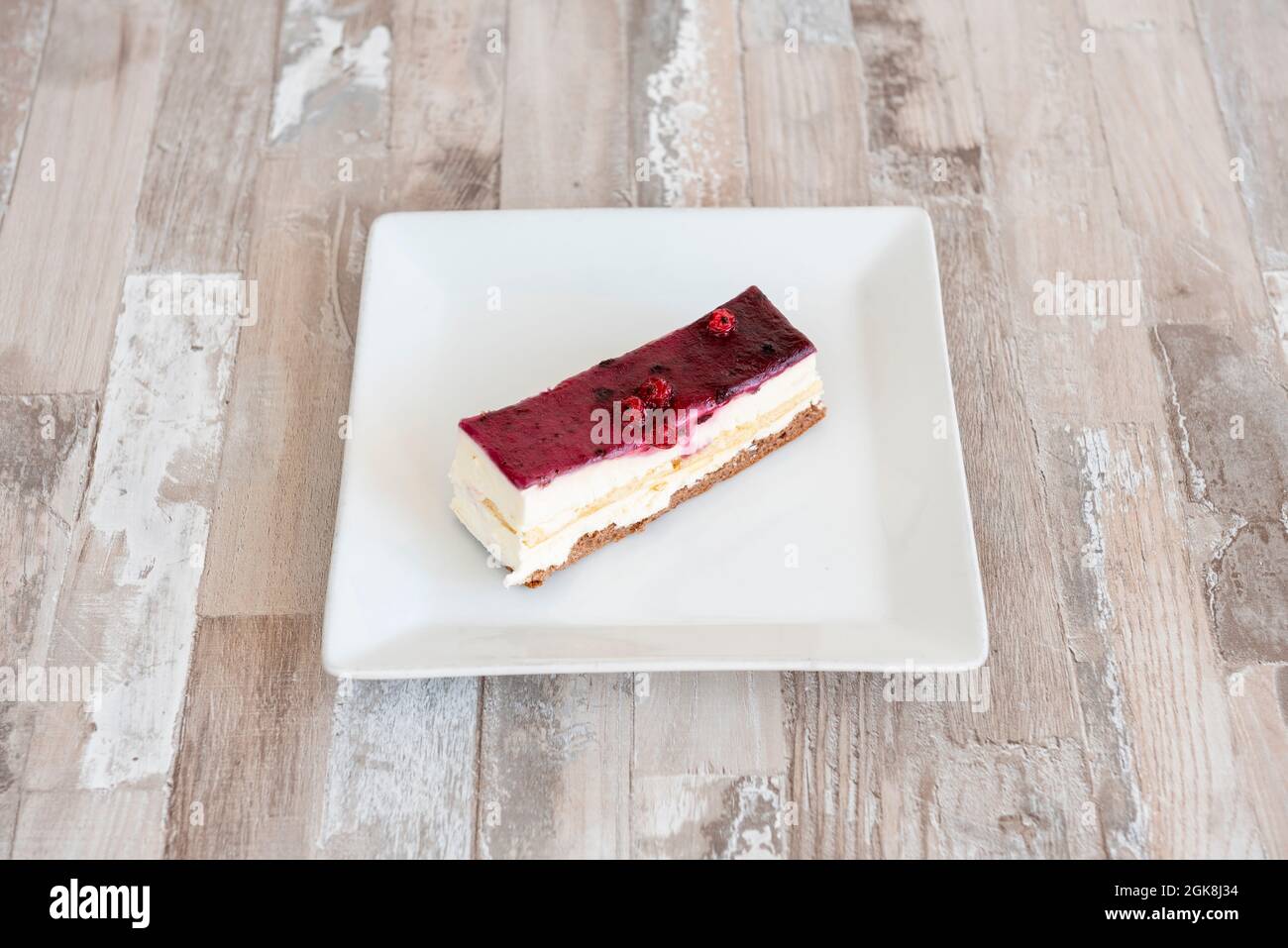 Porzione di cheesecake con confettura di mirtilli su piastra bianca Foto Stock