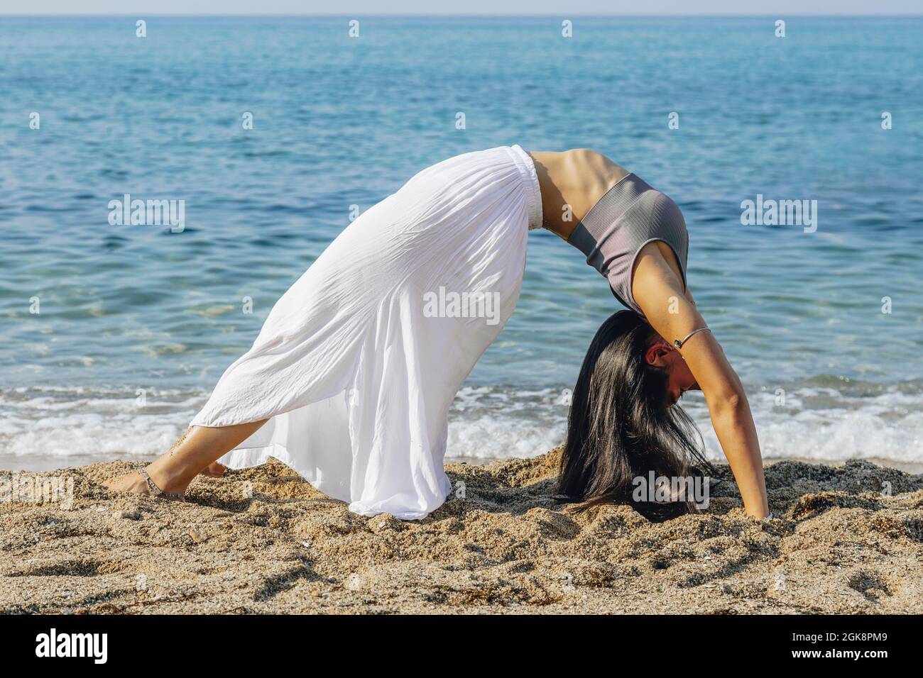 Vista laterale corpo intero di femmina a piedi nudi sottile con chiuso Occhi che si piegano in avanti mentre meditano in posizione Big Toe Foto Stock