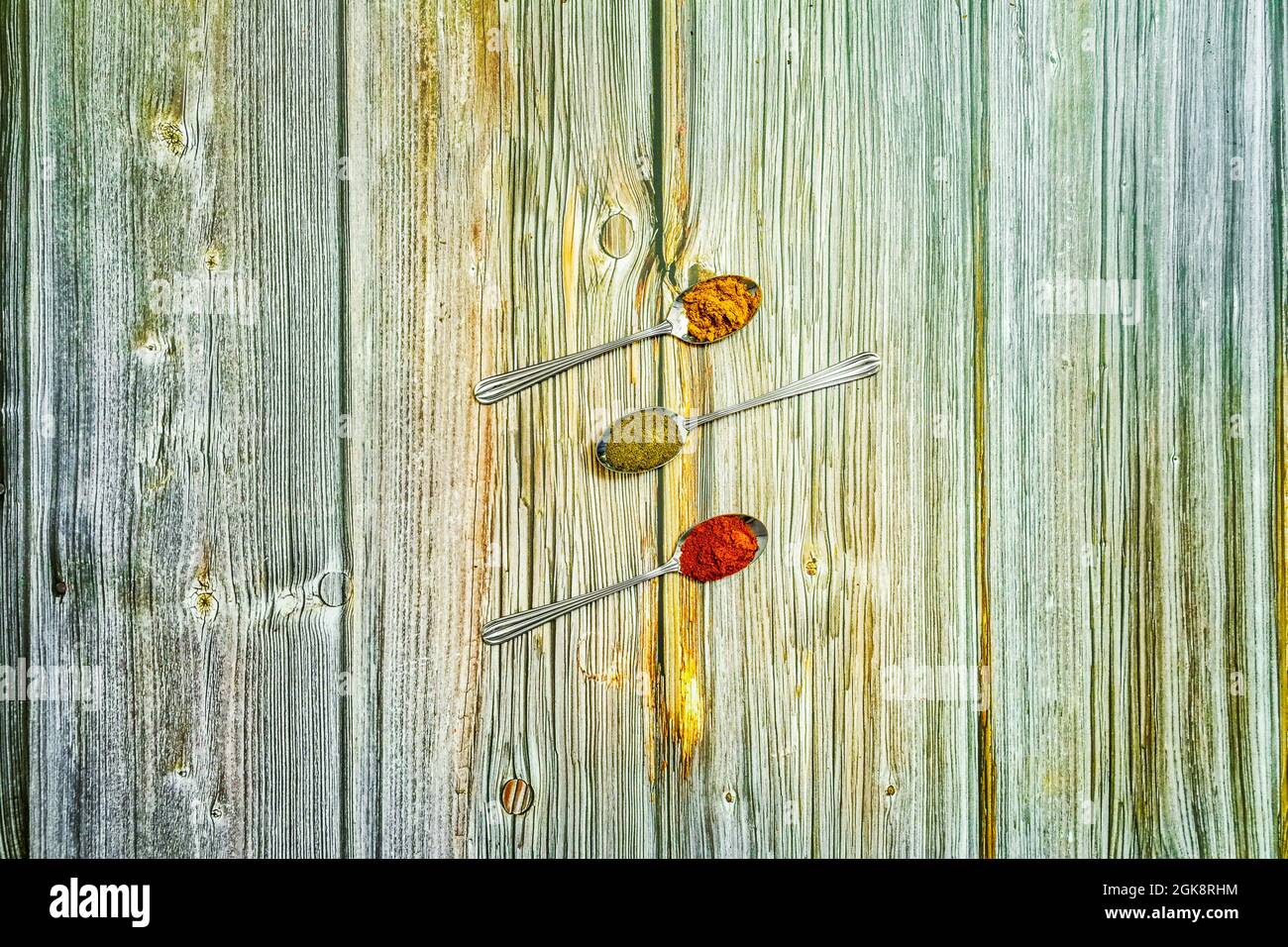 tre cucchiai di metallo con spezie in polvere. Aggiungere il curry, cuchara con la paprika e il cucchiaio con il pepe nero. Foto Stock