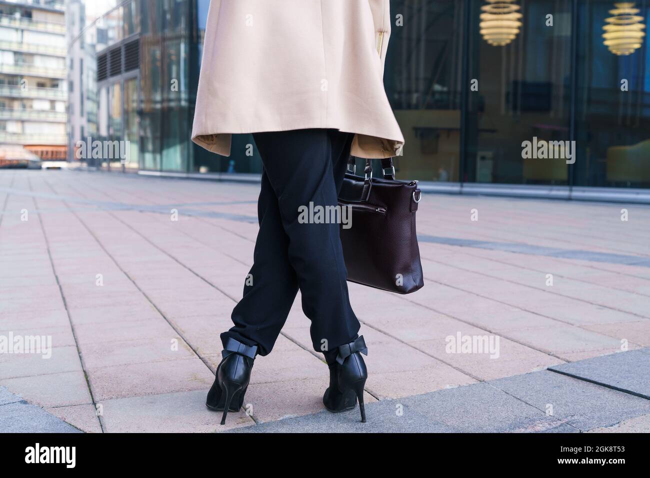 le gambe femminili si levano in piedi, donna di affari sulla strada vicino all'edificio dell'ufficio. Foto senza volto Foto Stock