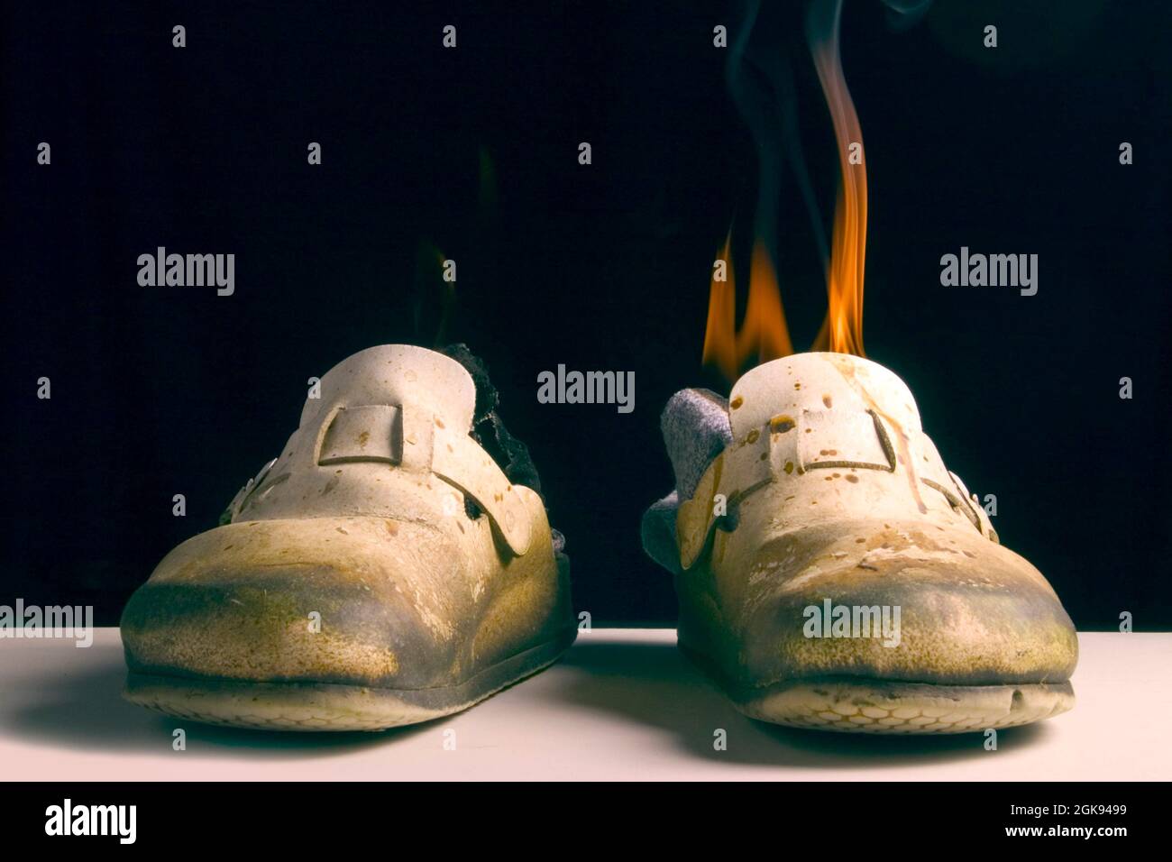 vecchia scarpa sporca con calzino burnung Foto Stock