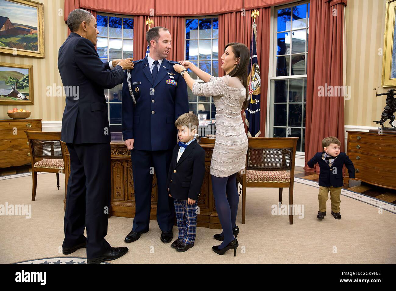 Il Presidente Barack Obama partecipa a una cerimonia di promozione per l'Aide militare maggiore Matthew 'Matt' Newell, USAF, promuovendolo al rango di tenente colonnello, presso l'Ufficio ovale, 5 dicembre 2014. Alla cerimonia partecipano anche la moglie di Newell, Tiffany Newell, e i figli Brody, 4, e Rowan, 2. (Foto ufficiale della Casa Bianca di Pete Souza) questa fotografia ufficiale della Casa Bianca è resa disponibile solo per la pubblicazione da parte delle organizzazioni di notizie e/o per uso personale la stampa dal soggetto(i) della fotografia. La fotografia non può essere manipolata in alcun modo e non può essere utilizzata in ambito commerciale o p Foto Stock