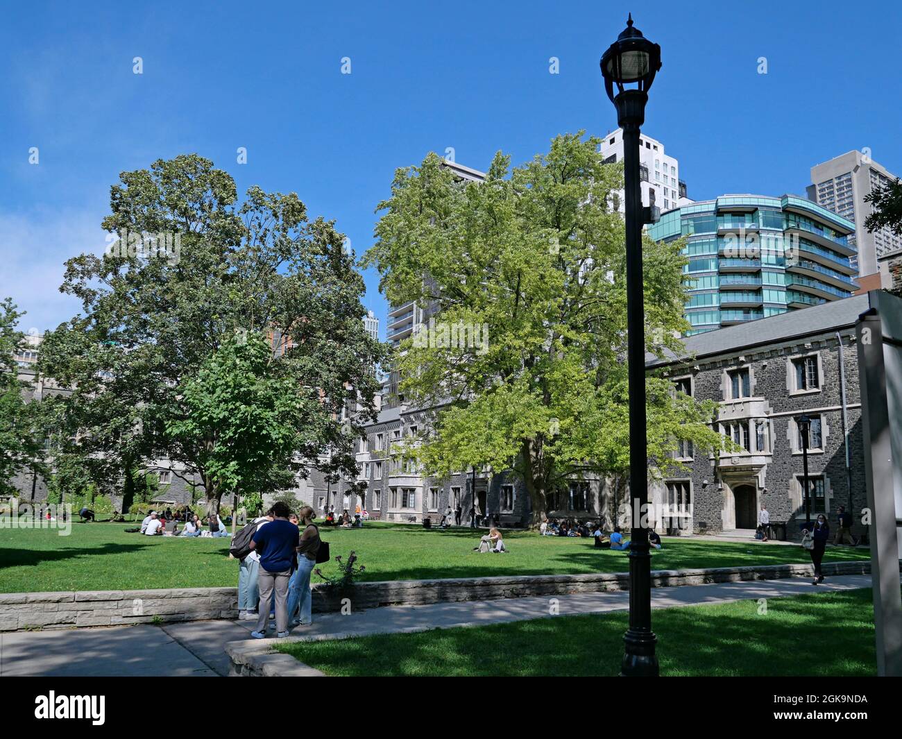 Toronto, Canada - 13 settembre 2021: All'inizio dell'anno accademico gli studenti godono di una calda giornata di sole sul prato del Victoria College. Foto Stock