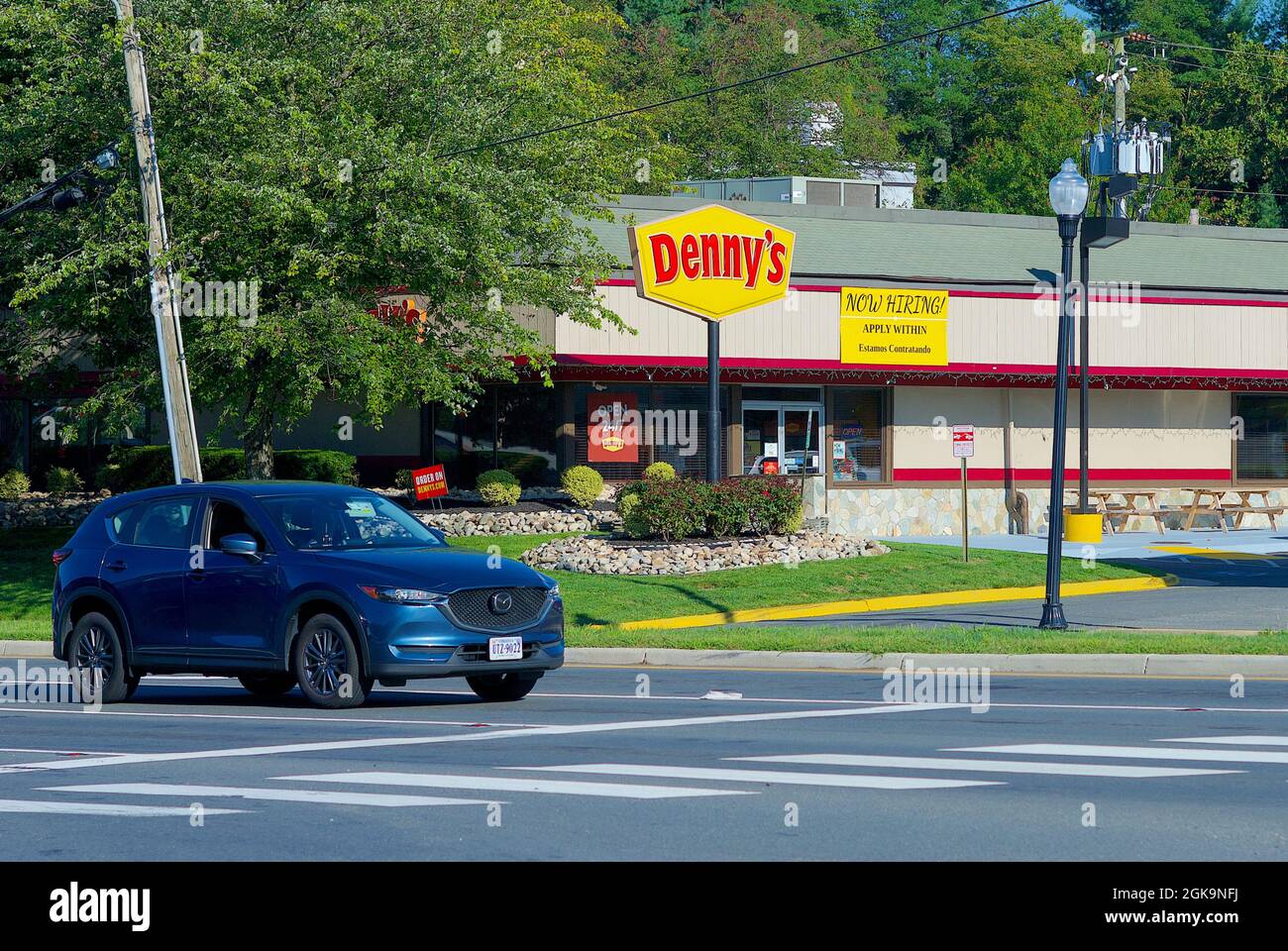 Fairfax, Virginia, Stati Uniti d'America - 3 settembre 2021: Un'auto passa un ristorante Denny's con un cartello "Now Hiring" in cerca di nuovi dipendenti per riempire le posizioni vacanti. Foto Stock