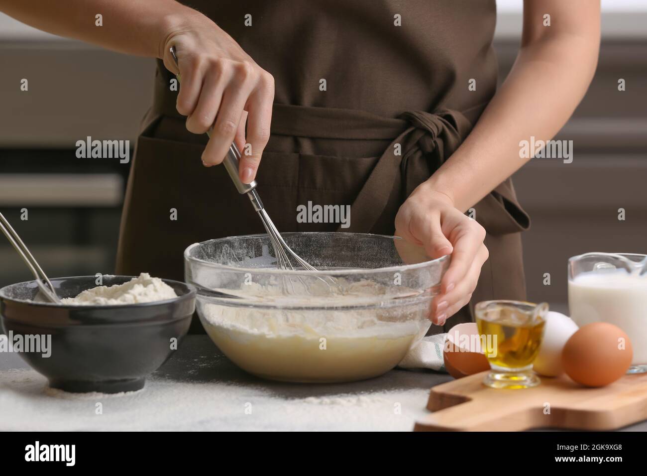 Chef femmina che prepara l'impasto in una ciotola di vetro sul tavolo da  cucina Foto stock - Alamy