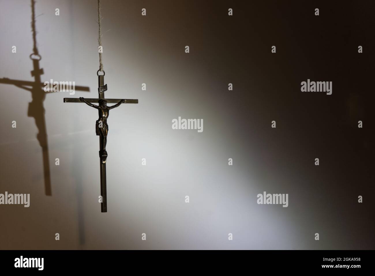 Piccola statua di Gesù Cristo sulla croce sullo sfondo di un muro Foto Stock