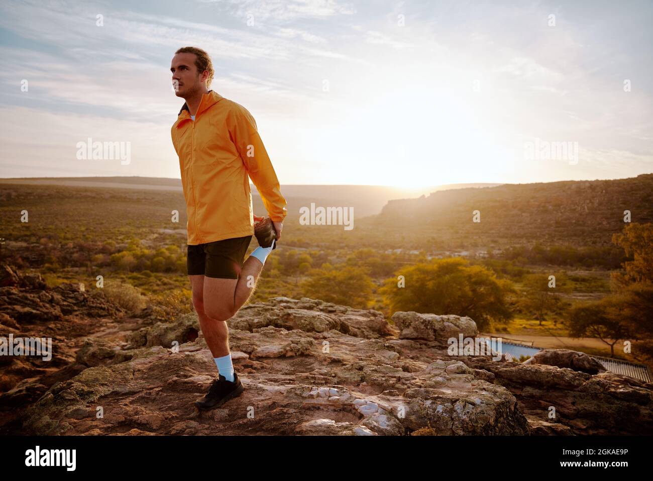 Uomo che si allunga e si prepara per l'allenamento e la corsa all'aperto Foto Stock