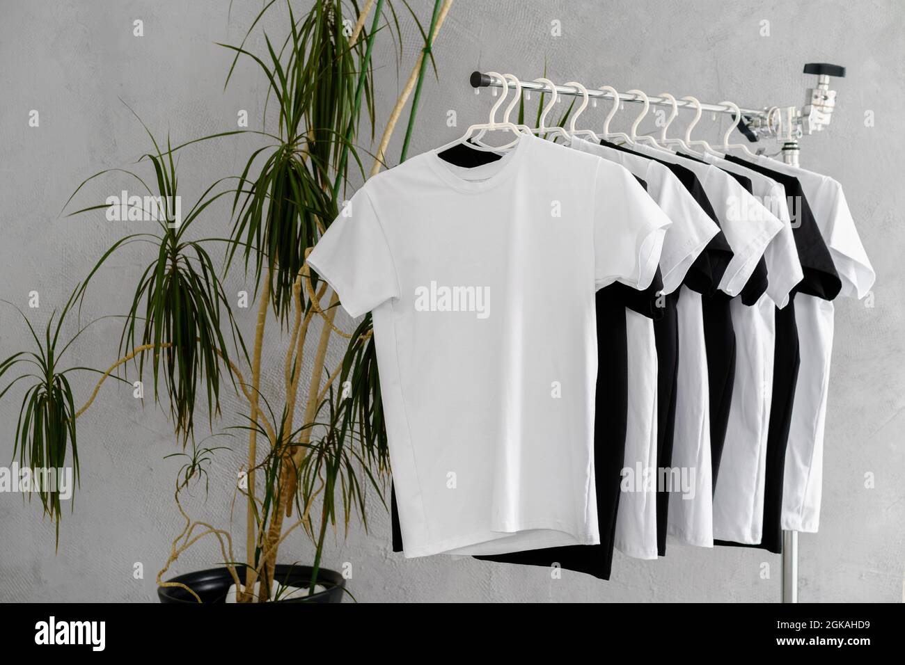 Fila di magliette bianche e nere appese sul rack Foto stock - Alamy