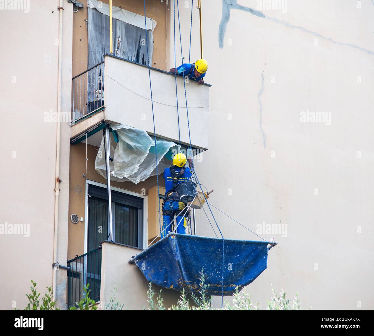 GENOVA, 31 LUGLIO 2021 - uomini di una società di costruzioni che lavorano su una facciata di un edificio a Genova. Foto Stock
