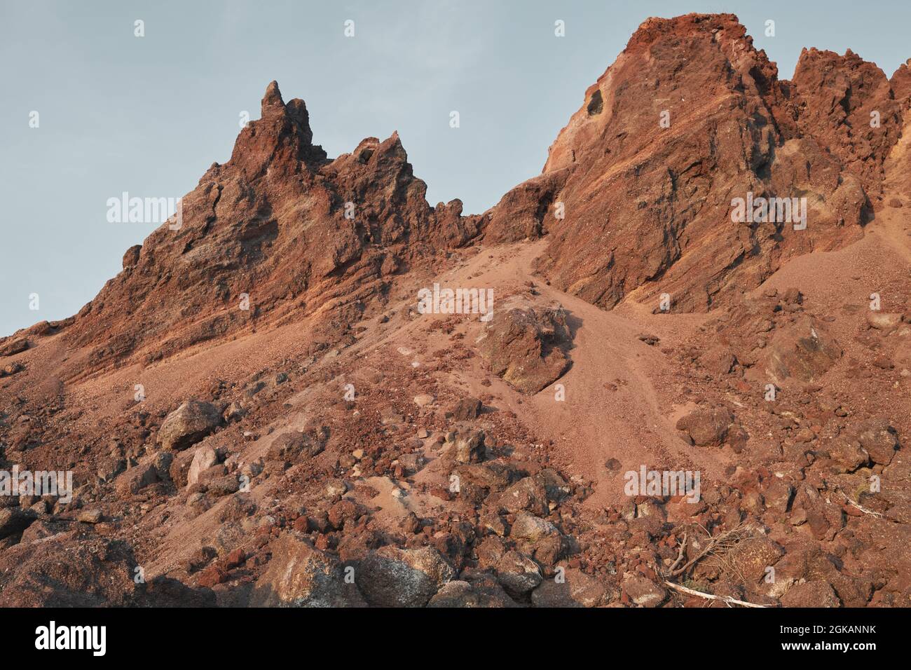 Un altopiano tra le montagne circondato da montagne rocciose di picco sotto un cielo blu chiaro Foto Stock