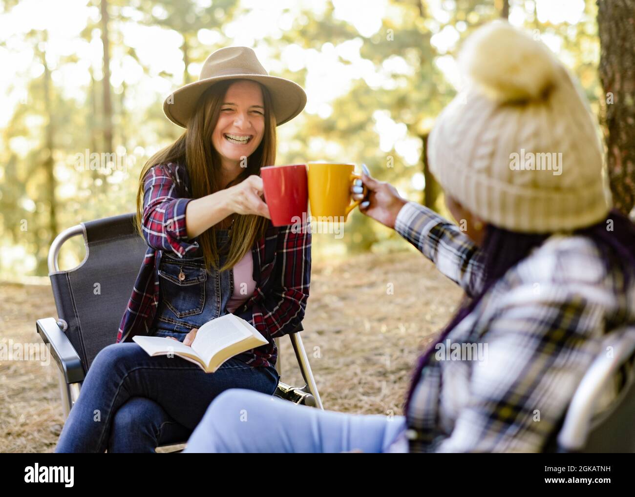 Soddisfare diversi viaggiatori che si aggraffano tazze nella foresta Foto Stock