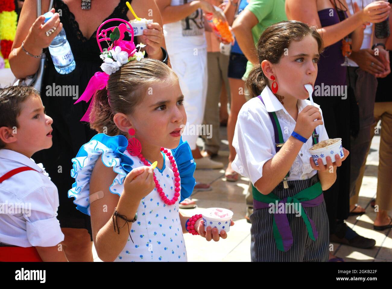 Bambini in abito tradizionale mangiare gelato, Calle Marques de Larios, Feria de Malaga, Malaga, Spagna. Foto Stock