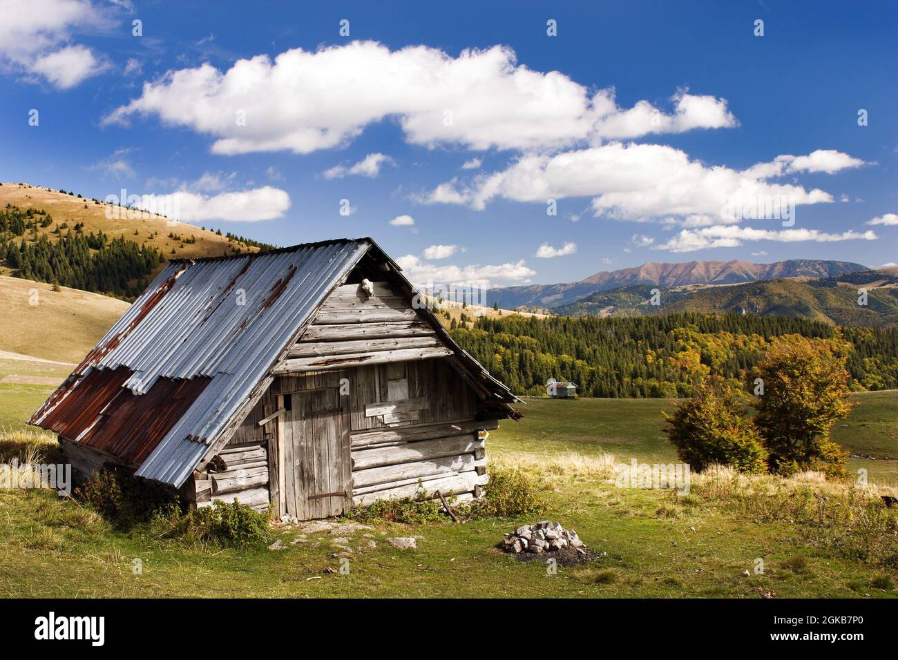 chalet boscoso sulle montagne con cielo e nuvole Foto Stock