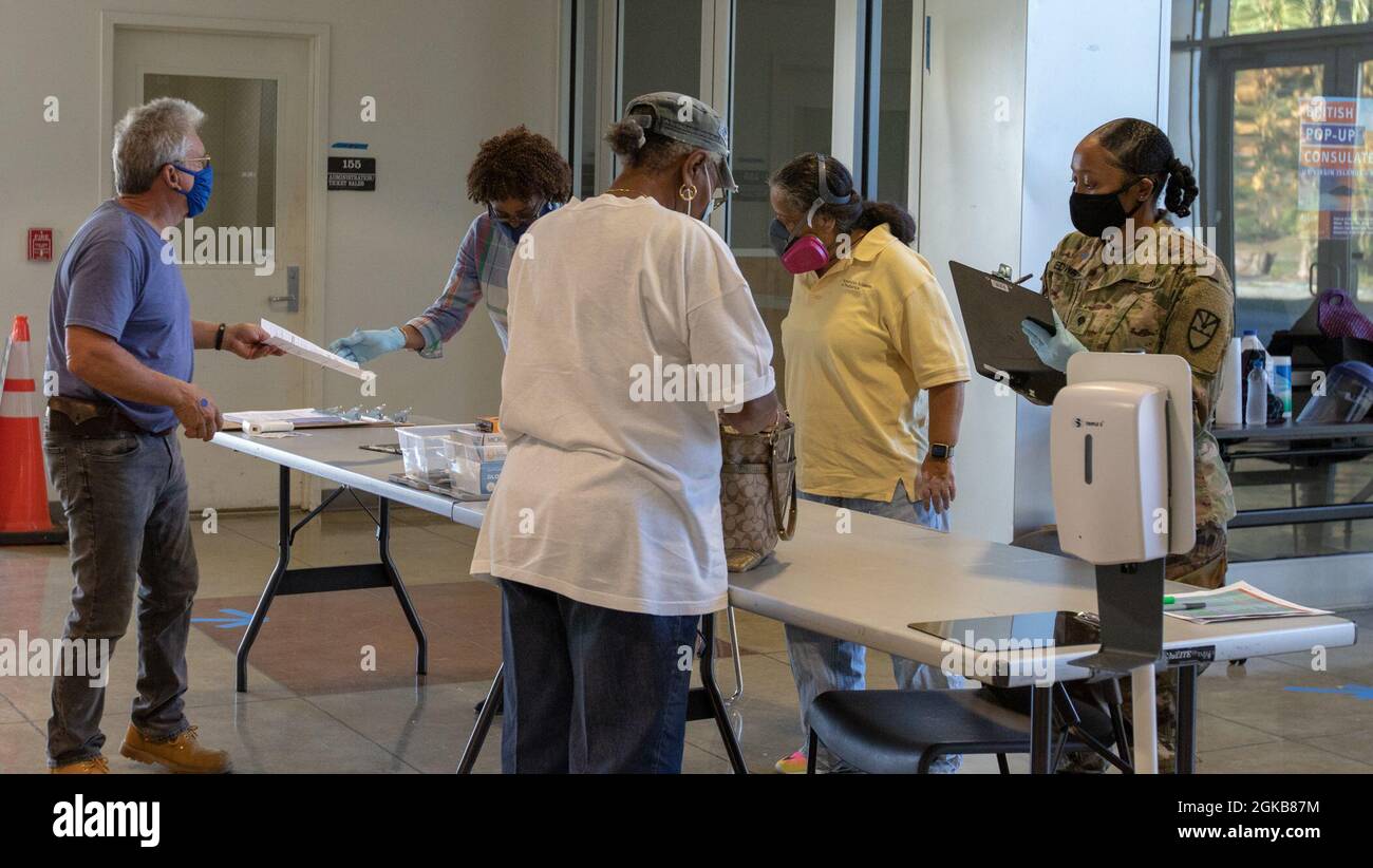 I membri della comunità locale di St. Thomas, Isole Vergini statunitensi, verificano le loro informazioni prima di ricevere un vaccino COVID-19 presso il Centro comunitario di vaccinazione dell'Università delle Isole Vergini - St. Thomas, 2 marzo 2021. Il comando del Nord degli Stati Uniti, attraverso l'Esercito del Nord degli Stati Uniti, rimane impegnato a fornire un supporto continuo e flessibile al Dipartimento della Difesa all'Agenzia federale di gestione delle emergenze come parte della risposta dell'intero governo al COVID-19. Foto Stock